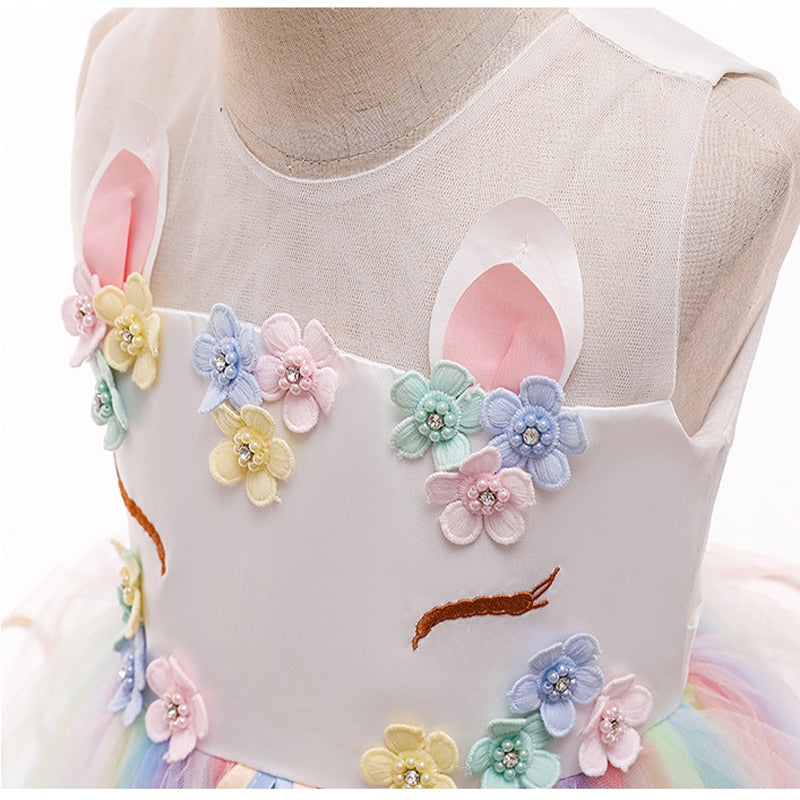 détails des fleurs multicolores sur le corset blanc du déguisement princesse licorne.