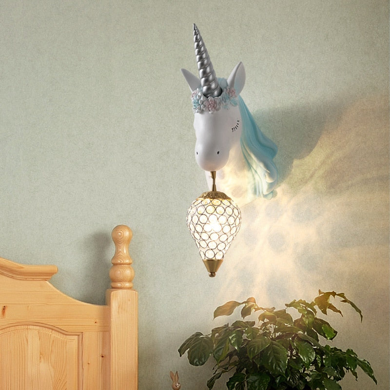 Trophée licorne lampe bleu accroché au dessus d'un lit dans une chambre