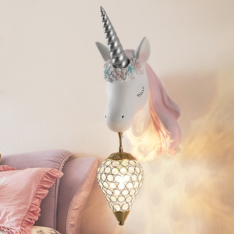 Trophée licorne lampe rose accroché au dessus d'un lit dans une chambre